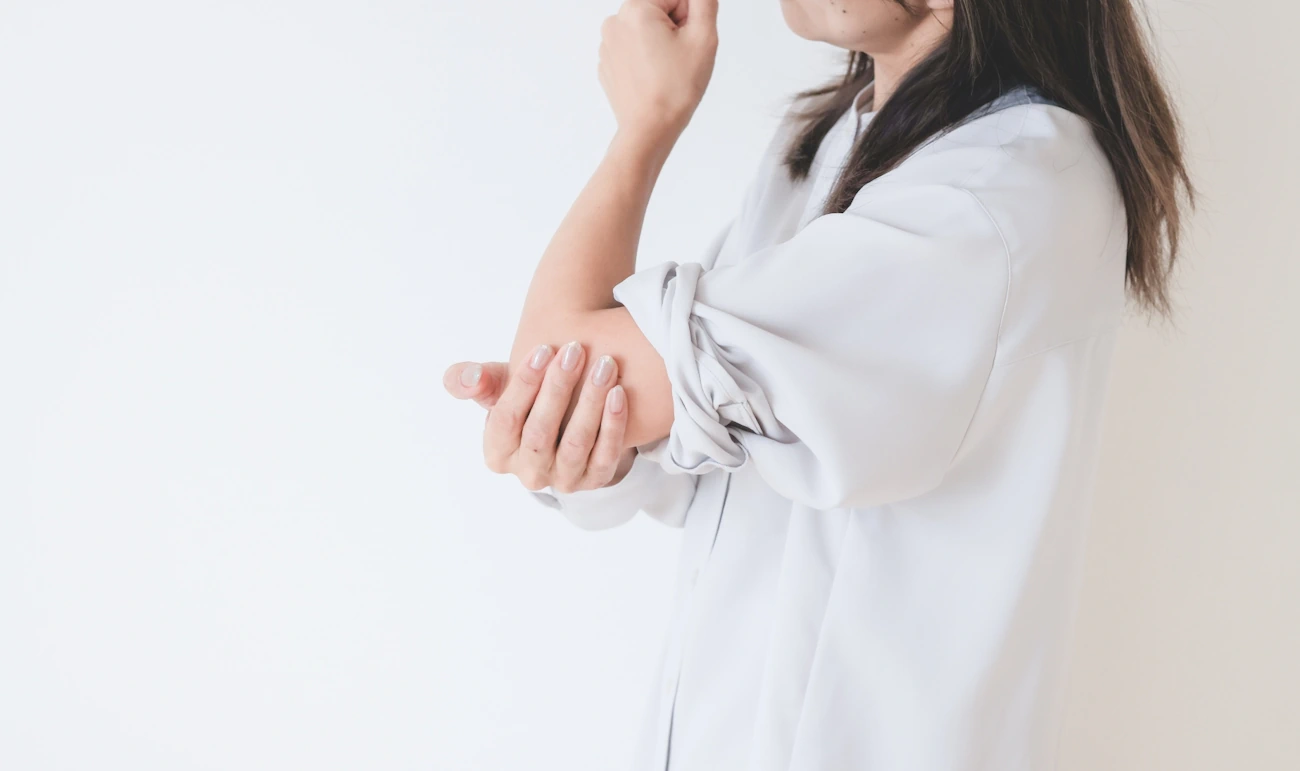 肘をおさえている女性