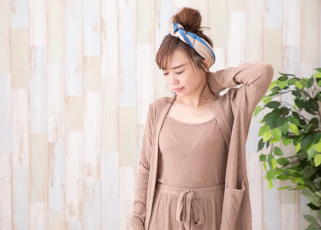 首をおさえて痛そうな女性
