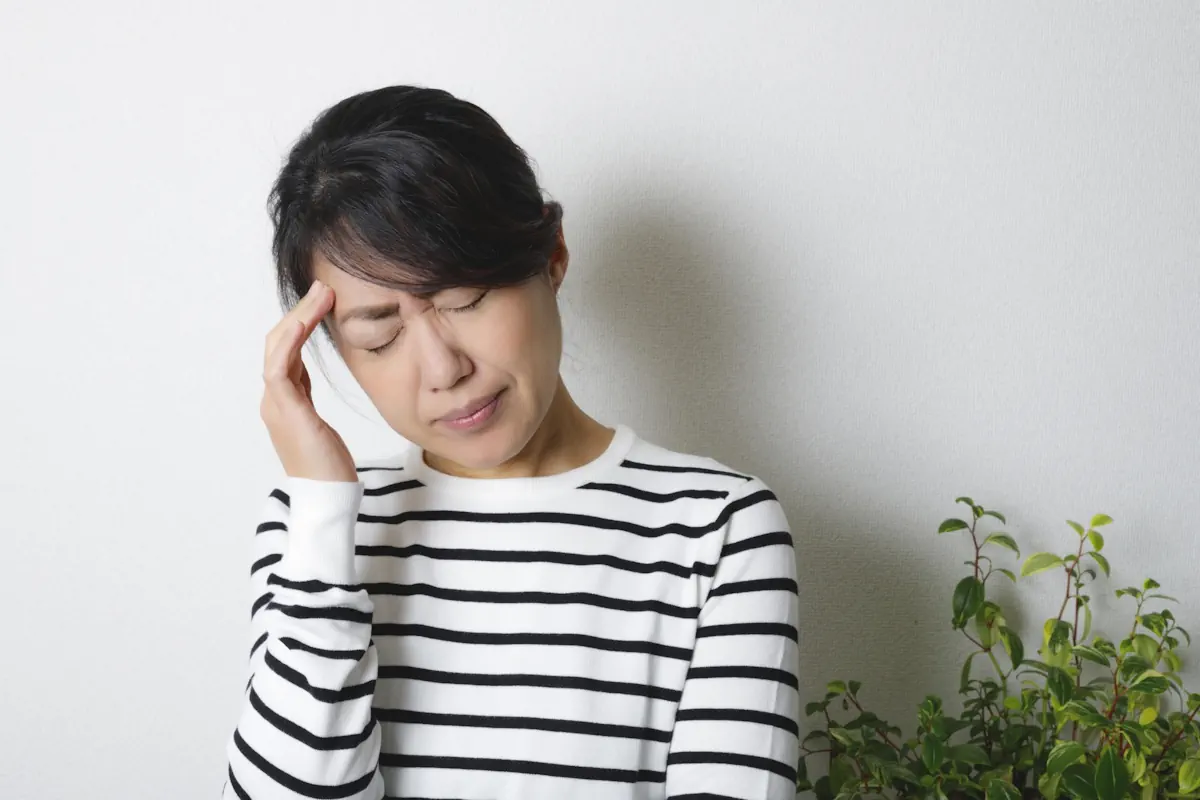 頭をおさえている女性